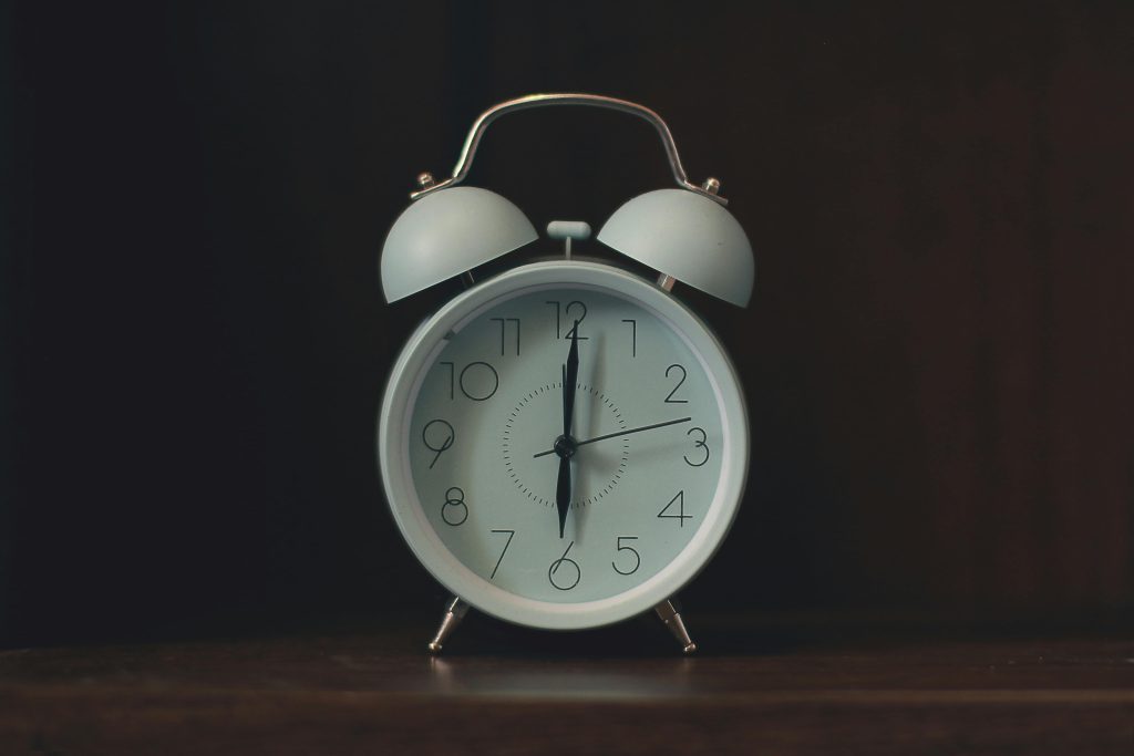 A clock sitting on a table with a dark background